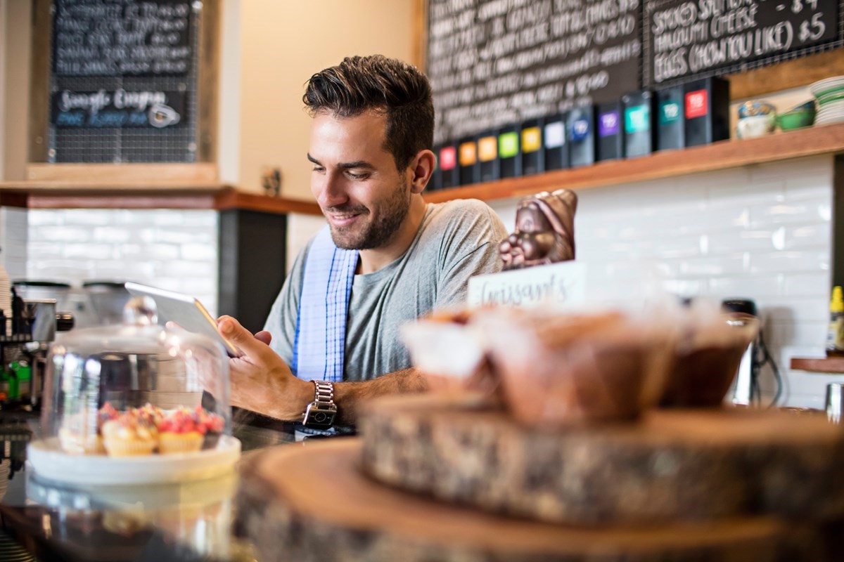 An employee looking at their phone in a cafe