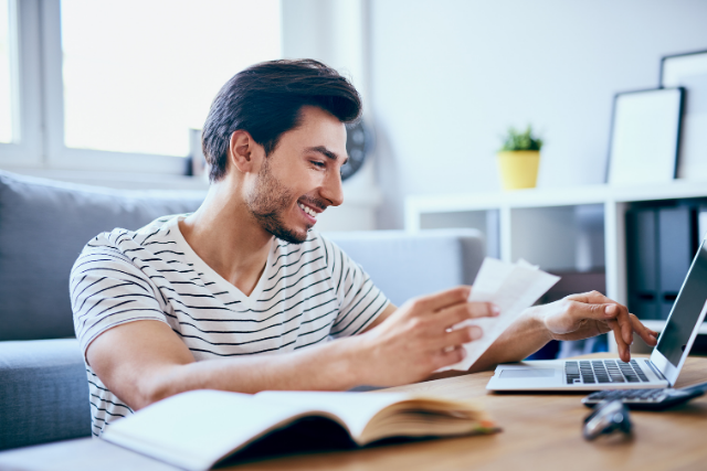 Male entering receipts on their laptop